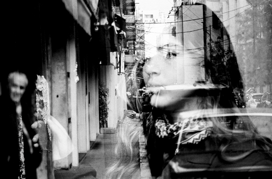 a double exposure image of a young woman and an old lady against an old street
