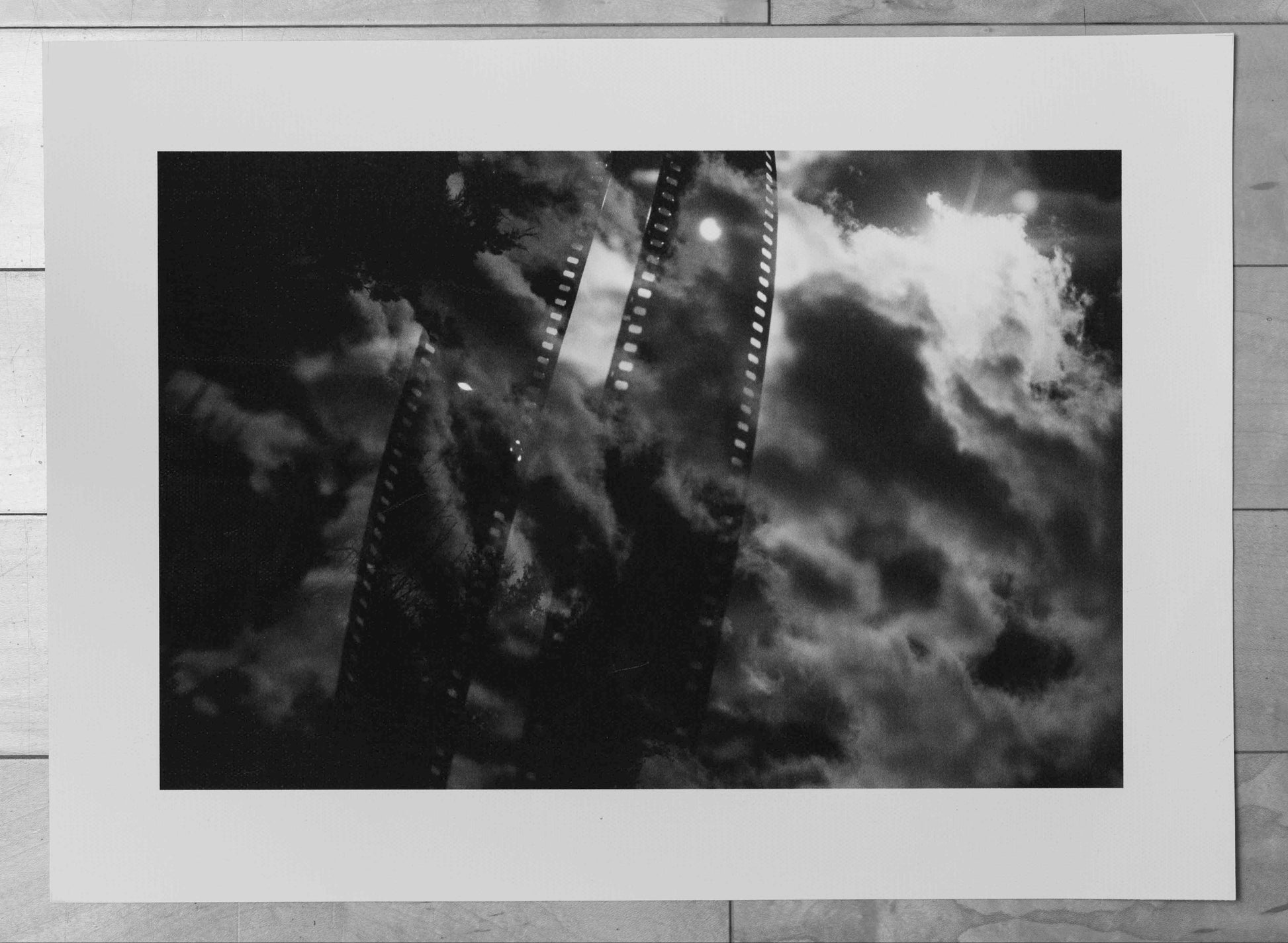 Black and white photo of a roller coaster with a frame on a wooden surface